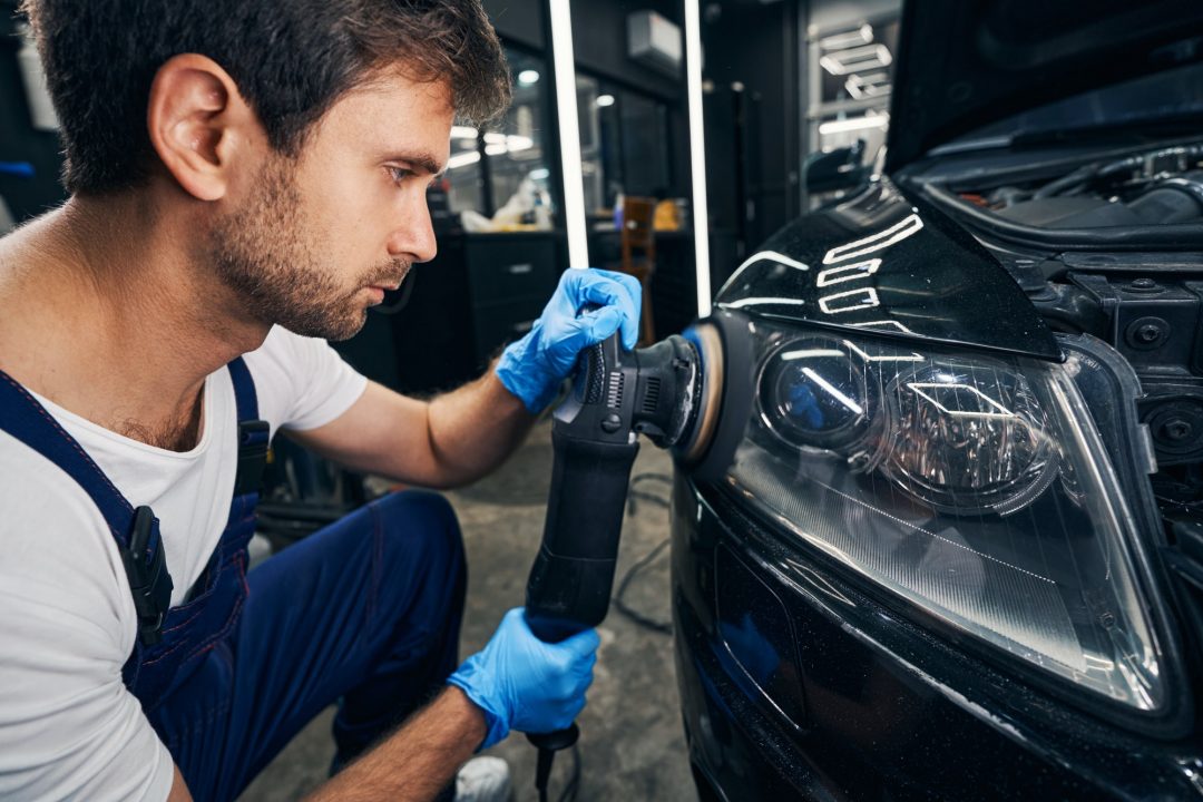 automobile-headlight-grinded-by-mechanic-with-polisher.jpg